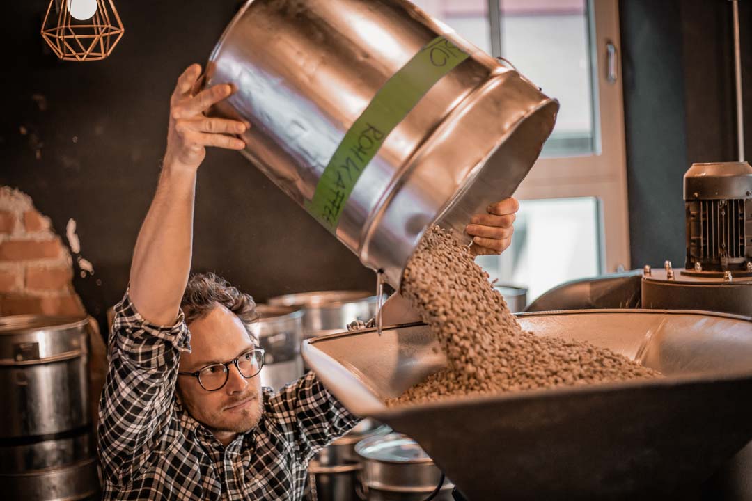 Röstmeister Valentin füllt den Rohkaffee in den Einfülltrichter
